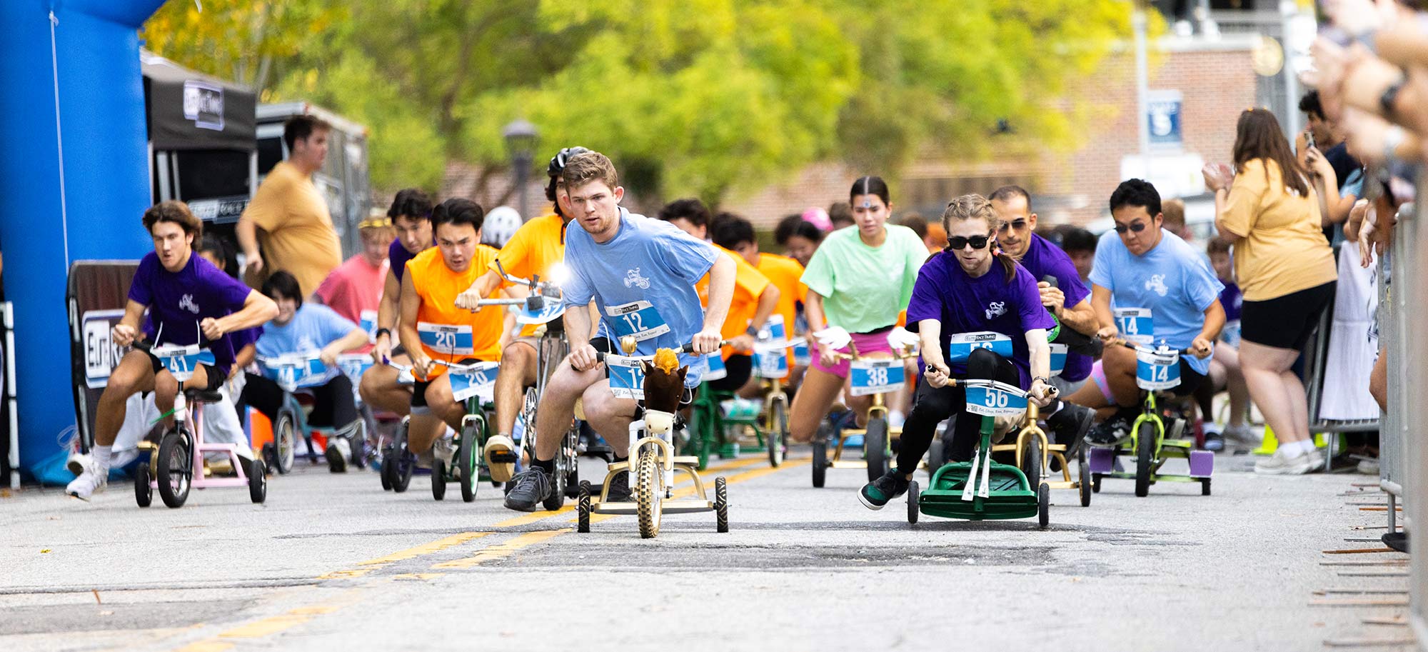 Student participating in Mini 500 tricycle race